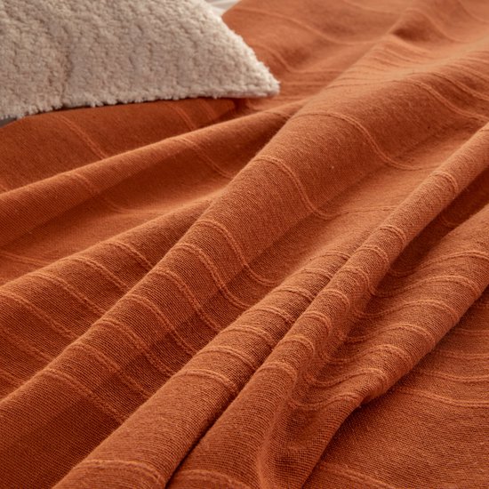 Gedetailleerde textuur van een terracotta plaid met horizontale strepen.