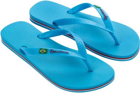 Turquoise Ipanema slippers met rode en witte strepen op de zool. Braziliaanse vlag op de bandjes.