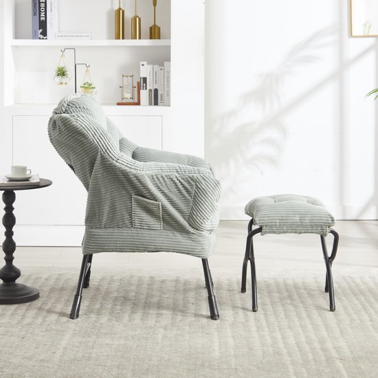 Lichtgroene corduroy fauteuil met voetenbankje in een woonkamer.