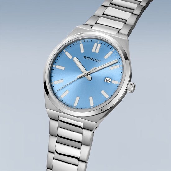 Zilverkleurig herenhorloge met blauwe wijzerplaat. De wijzerplaat heeft een datumweergave. Het horloge heeft een metalen band.