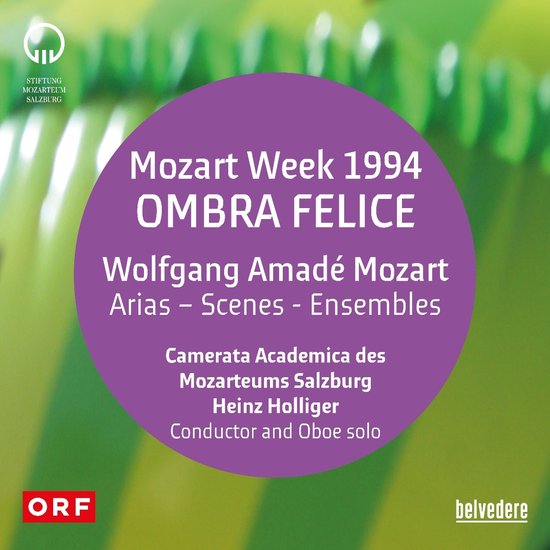 Paars cirkelvormig vlak op een groengele achtergrond. Tekst over Mozart Week 1994, opera, uitvoerders en dirigent Heinz Holliger.