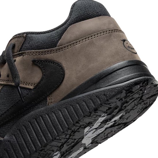 Zool van een bruine en zwarte lage sneaker met de tekst 'Jack' erop.