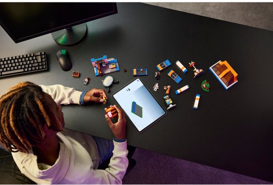 Enfant construisant du LEGO Fortnite avec une tablette, des figurines et des pièces du restaurant