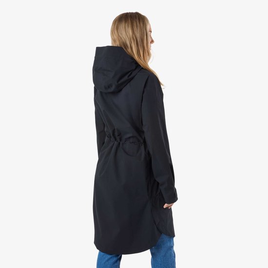 Vue de côté d'une femme portant un long manteau noir à capuche et un jean.