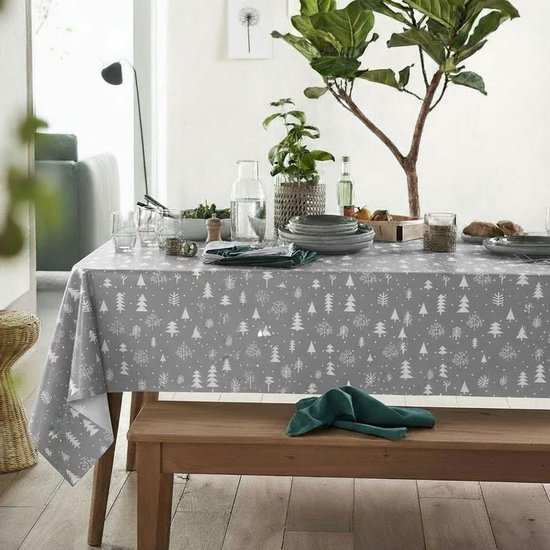 Nappe grise à motif d'arbres de Noël blancs, dressée sur une table de salle à manger dans un salon.