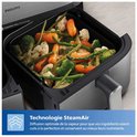 Philips airfryer mand gevuld met gestoomde groenten zoals bloemkool, wortel, broccoli en asperges.