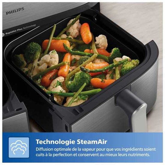 Philips airfryer mand gevuld met gestoomde groenten zoals bloemkool, wortel, broccoli en asperges.