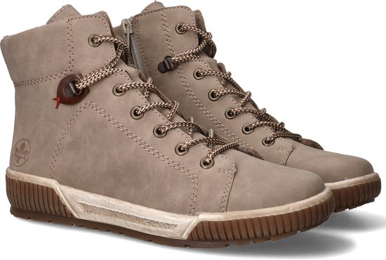 Paar beige hoge veterschoenen met bruine veters, bruine zolen en een bruine veterring.