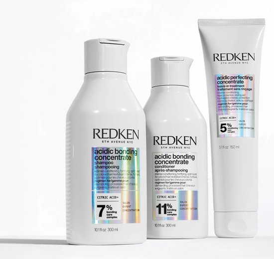 Trois flacons Redken : shampooing, après-shampoing et tube de produit sans rinçage.