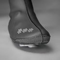 Close-up van de neus van een zwarte "GripGrab" overschoen met sneeuwvlokken en verstevigde zool.