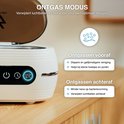 Witte ultrasone reiniger met digitaal display en knoppen, met bubbels die opstijgen uit het water.