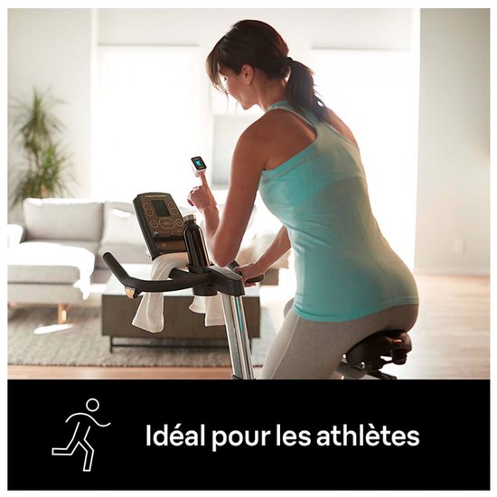 Vrouw op hometrainer met polsoximeter, ideaal voor atleten