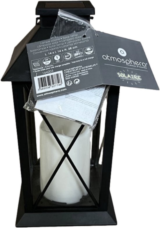 Zwarte lantaarn met zonnecel, LED-kaars, en label met productinformatie.