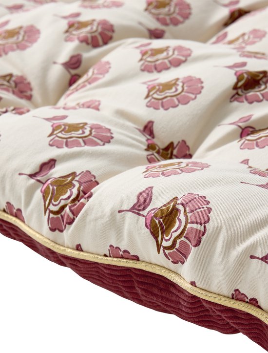 Detail van een lichtroze vloermatras met bloemenprint en een roze corduroy rand.