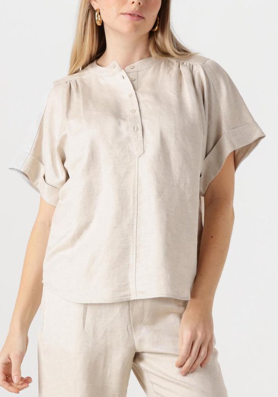 Model in beige linnen blouse met korte mouwen en kraagloze hals.