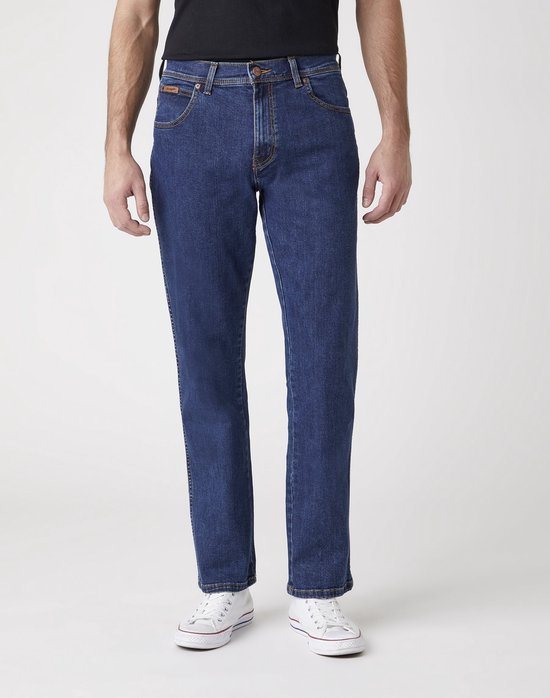 Blauwe Wrangler jeans, regular fit, gedragen met zwart T-shirt en witte sneakers.