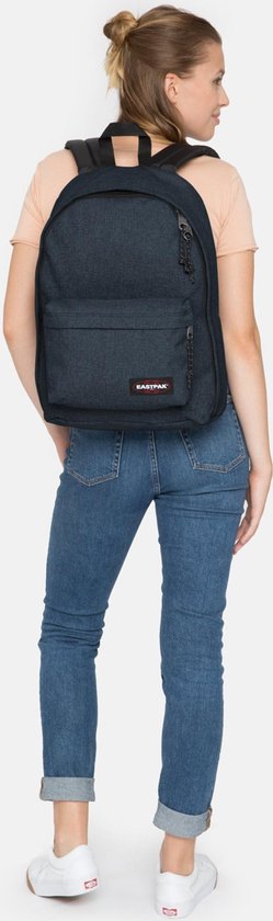 Vrouw met donkerblauwe Eastpak rugzak en spijkerbroek.