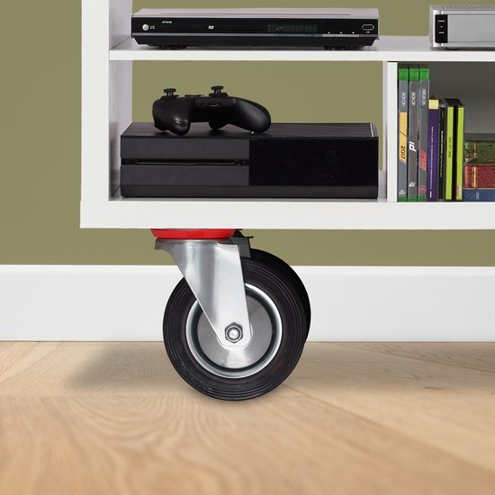 Zwart zwenkwiel met een rode rem op een houten vloer, onder een witte plank met elektronica.
