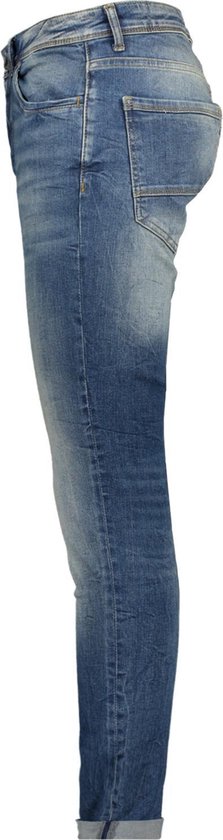 Zijaanzicht van een slanke, blauwe spijkerbroek met licht vervaagde plekken en opgerolde broekspijpen.