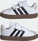 Twee witte adidas sneakers met bruine zolen en klittenbandsluitingen.