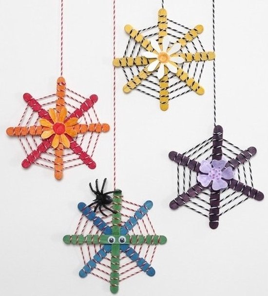 Vier spinnenwebdecoraties gemaakt van gekleurde ijsstokjes, touw en bloemen.