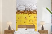 Behang - Fotobehang Bierbubbels in glas met bier - Breedte 120 cm x hoogte 240 cm