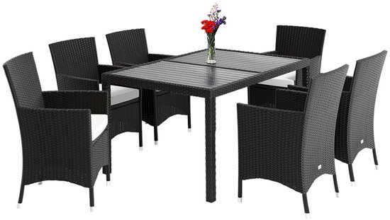 Zwarte 8-persoons polyrotan tuinset met tafel en stoelen, met vaas bloemen op tafel.