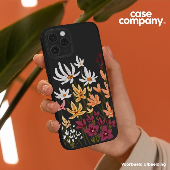 Hand toont zwarte telefoonhoes met schilderkunstige bloemenprint.