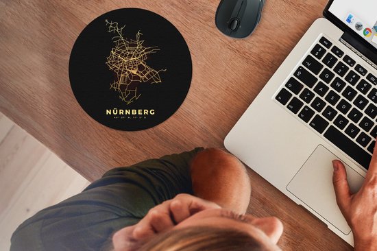 Ronde zwarte muismat met een gouden plattegrond van Nürnberg, naast een laptop en muis.