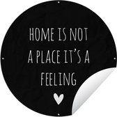 Tuincirkel Engelse quote "Home is not a place it's a feeling" met een hartje tegen een zwarte achtergrond - 90x90 cm - Ronde Tuinposter - Buiten