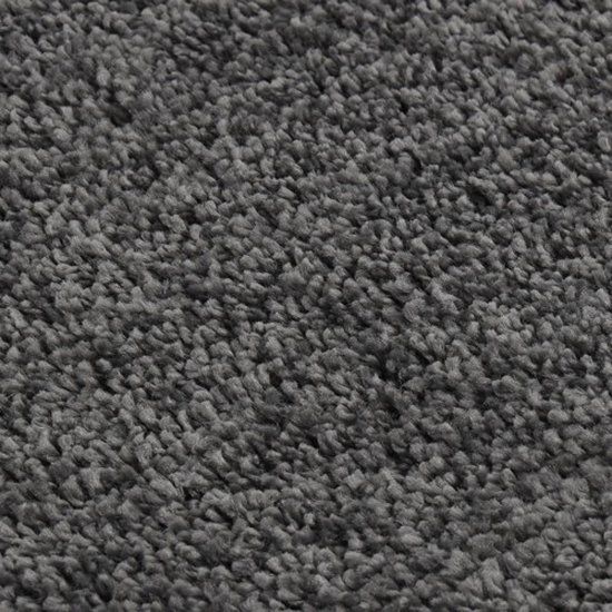Close-up van een donkergrijs shaggy vloerkleed met zachte vezels.