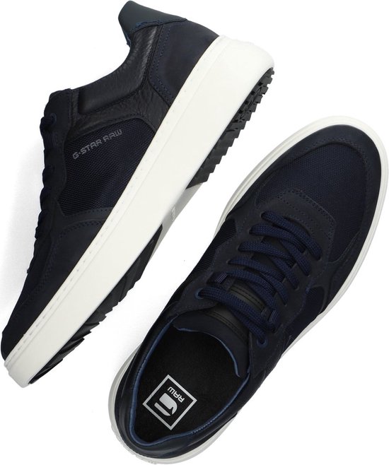 Paar donkerblauwe G-Star Raw sneakers, een van bovenaf gezien. Witte zolen. Suède, mesh en lederen details.