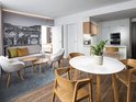 Een modern appartement met een woonkamer en keuken, een eethoek en een zithoek met een tweepersoonsbed in de slaapkamer.