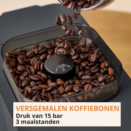 Verse koffiebonen vallen in de maalunit van een zwarte Krups koffiemachine met 3 maalstanden.