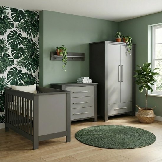 Babykamer met donkergrijs ledikant, commode en kast, tegen een muur met groen bladmotief.