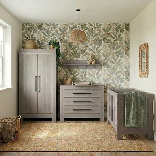 Babykamer met grijs ledikant, commode, kledingkast, behang met bladeren en luipaarden, en rieten manden.