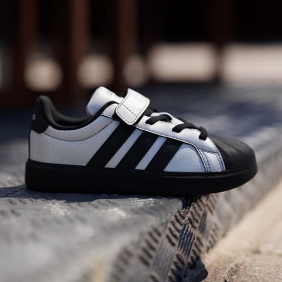 Zilveren Adidas kindersneaker met zwarte strepen, klittenband en zwarte neus.