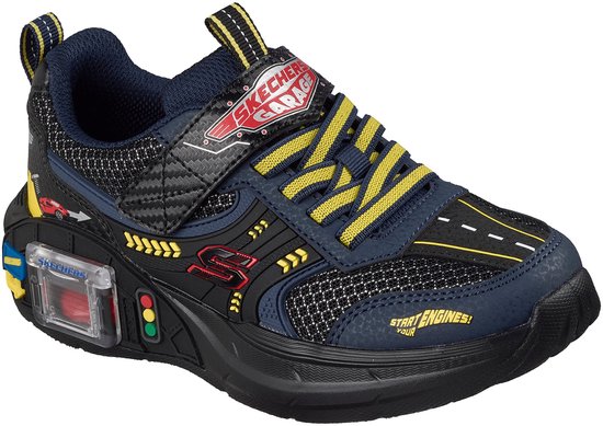 Blauwe sneaker met gele veters, klittenbandsluiting, verkeerslicht-detail en "START ENGINES!" tekst.