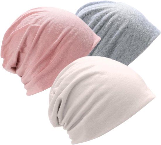 Drie zachtvallende beanies in pastelroze, beige en grijs, gemaakt van katoen.