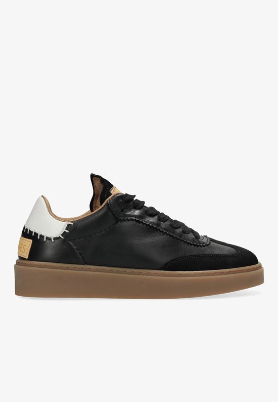 Zwarte leren sneaker met suède neus, bruine zool en witte hiel met stikwerk.