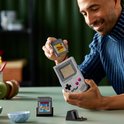 Homme tenant une LEGO Game Boy et une cartouche de jeu.