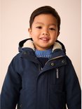 Close-up van lachend jongetje in donkerblauwe parka met teddy voering en blauwe trui.