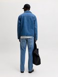 Model van achteren gezien, draagt een blauwe spijkerbroek met een rechte pasvorm en een lichtblauwe denim wassing.
