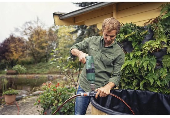 Man gebruikt Gardena voorzetpomp met boormachine om een tuinslang te verbinden met een vijverfolie.