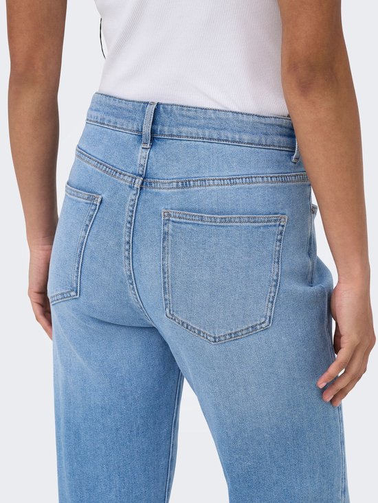 Model met lichtblauwe mom fit jeans met rechte pijpen, focus op de achterzakken.