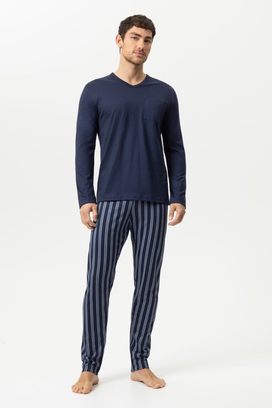 Man in marineblauwe pyjamaset met V-hals shirt en broek met blauwe strepen.