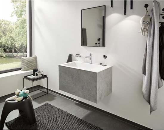 Chroom wastafelkraan in een moderne badkamer met grijze wastafel.