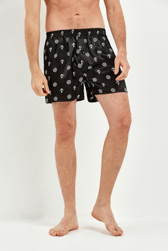 Model draagt een zwarte satijnen boxershort met een wit patroon van ankers en scheepsroeren.