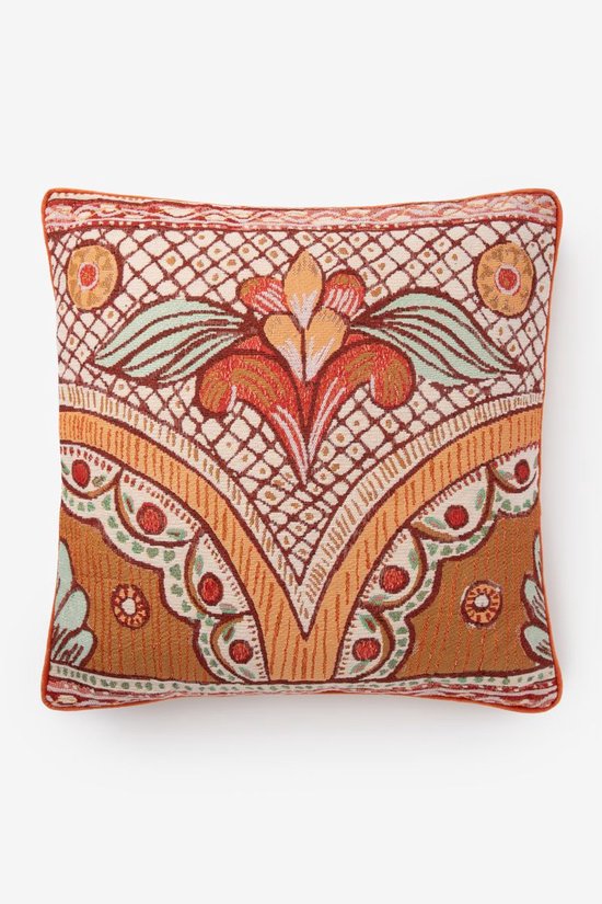 Een sierkussen met een rood en oranje bloemendessin, omlijst met oranje biezen.