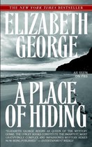 Boekcover van 'A Place of Hiding' van Elizabeth George. Een strandscène met voetsporen in het zand.